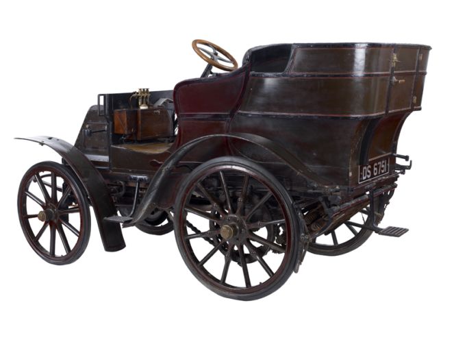 Metal and wood car with a steering wheel.  It looks more robust than earlier models.