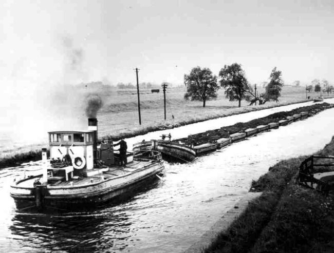 Black and white photo of barge carrying Tom Puddings full of coal