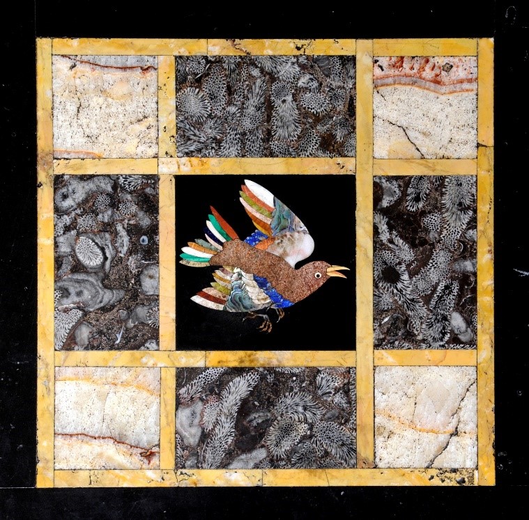 Detail of an inlaid marble table showing a bird in flight in the centre with different types of marble stone surrounding