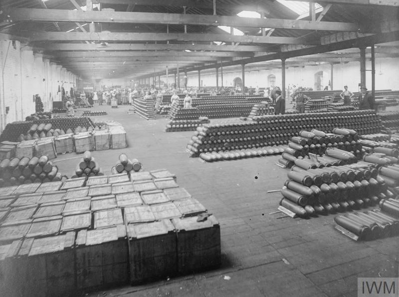 Female munition workers packing shells into crates in a factory at an undisclosed location