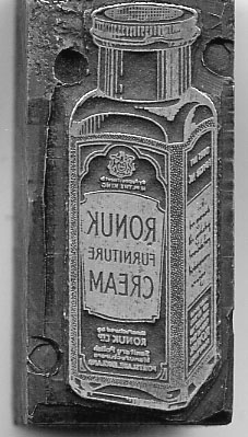 Metal block with an image of a tube of cream etched onto it in reverse