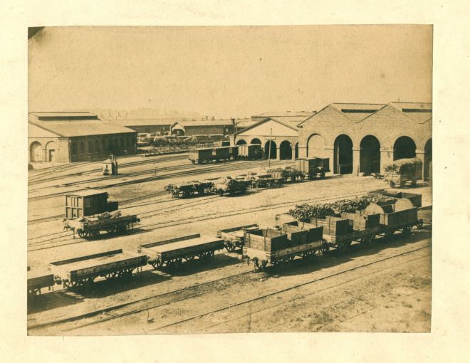 Wilson trains with carriages for carrying goods like coal.  There are multiple train track heading into buildings