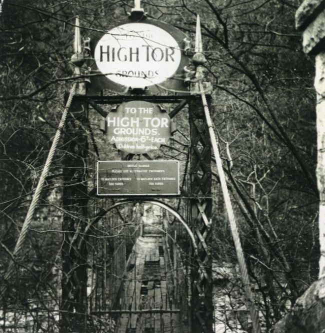 A photograph of the entrance to the High Tor Grounds, taken in the 1920s.  It shows a bridge protected by a metal gate.