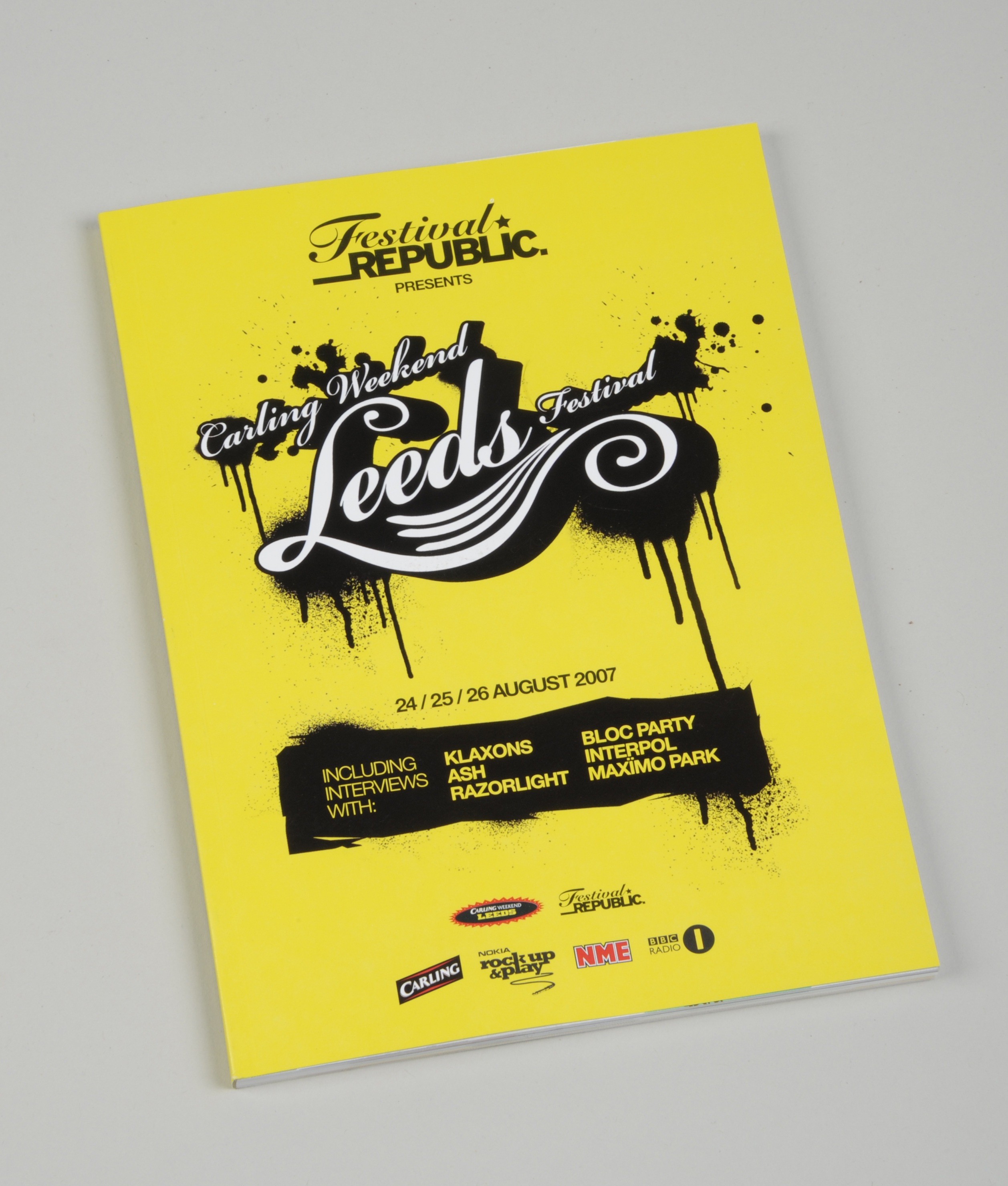 Yellow booklet with 'Festival Republic presents Leeds Festival' written in black and white on the front
