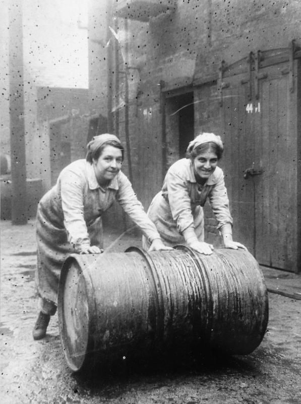 Female workers roll a barrel of varnish in the grounds of Sissons and Co. Ltd, Bankside, Hull in November 1918