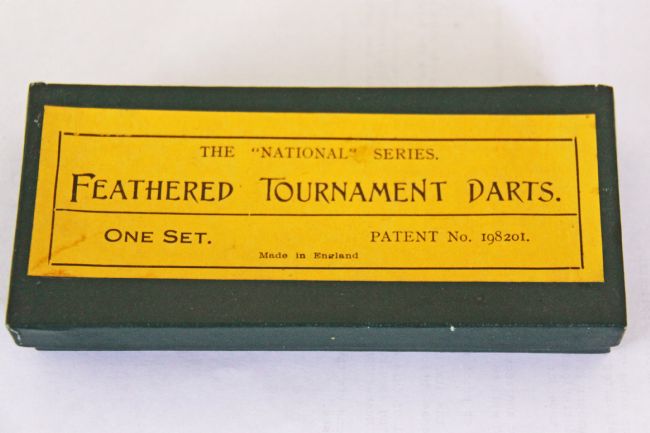 Box with a a yellow label stating 'Feathered Tournament Darts'.