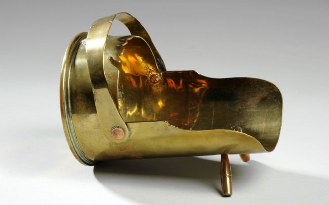 a miniature coal shuttle made from a brass shell casing.  The shuttle is very detailed, with a separate handle and two legs at the front.