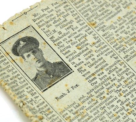 Black and white newspaper photograph showing the head and shoulders of a young soldier with 'Bomb. J. Fox' written underneath.