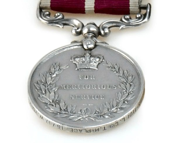Silver coloured medal shows laurel wreath with the words 'For Meritorious Service' engraved in the middle.