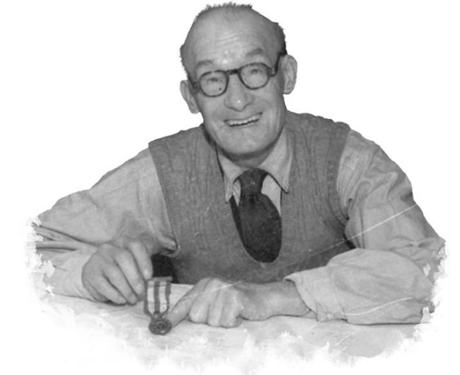 Black and white photograph of an elderly man holding a medal