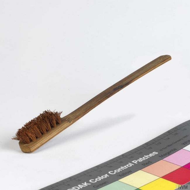 Used toothbrush with wooden handle.