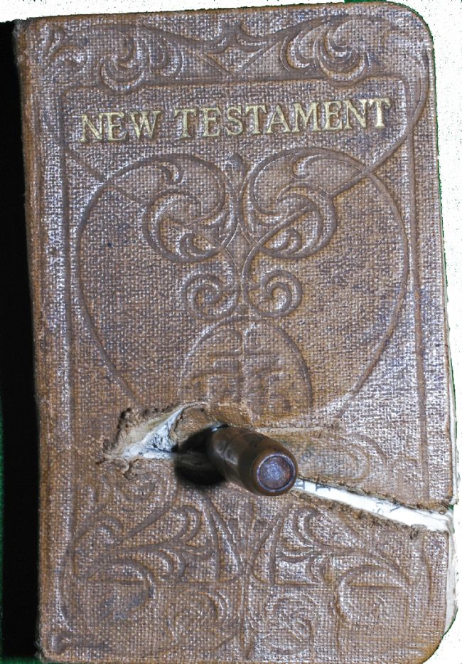 New Testament Bible  with a German bullet embedded in it