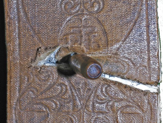 Detail showing the end of the bullet embedded in the bible