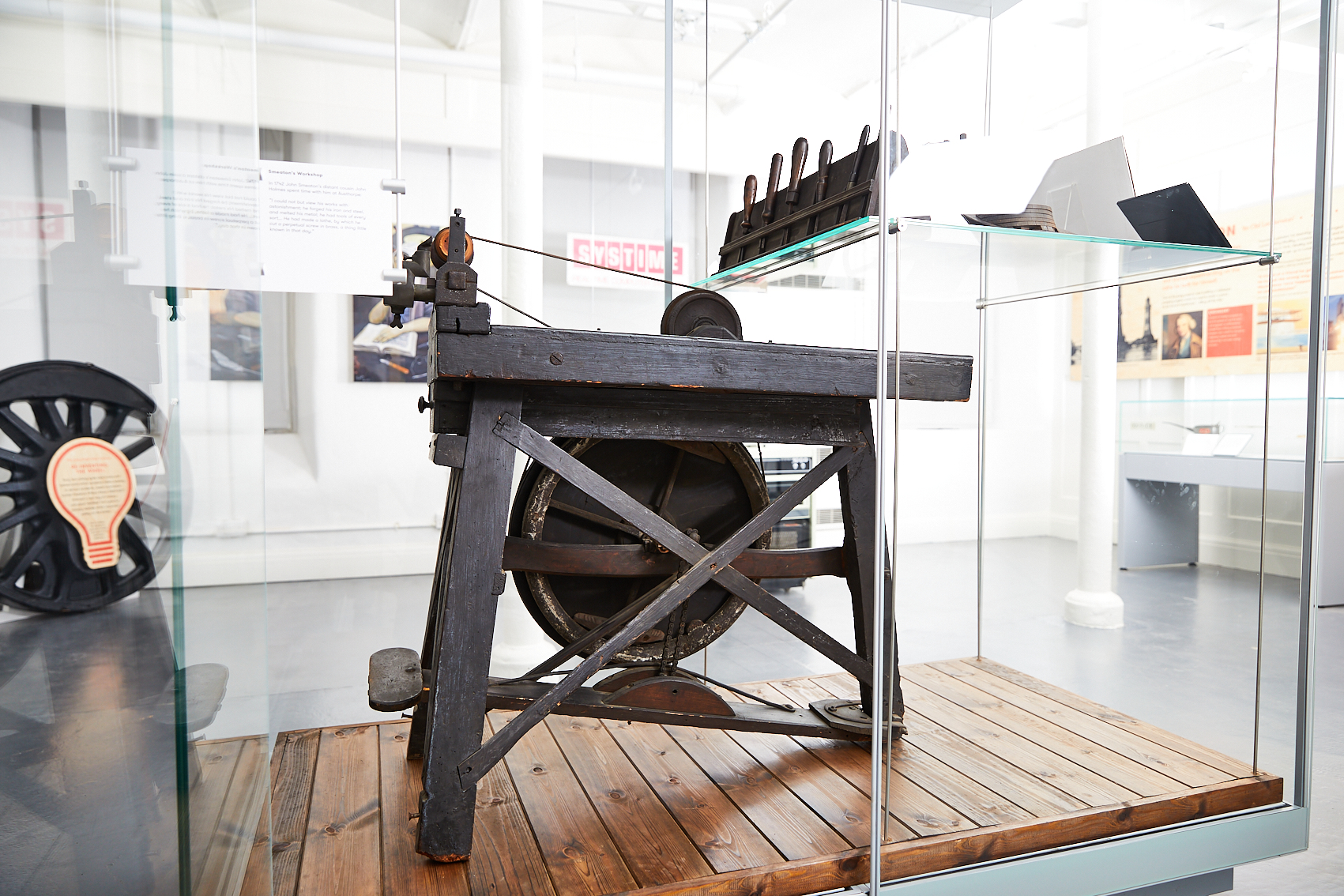 A photograph of a lathe inside a glass box on display in a museum