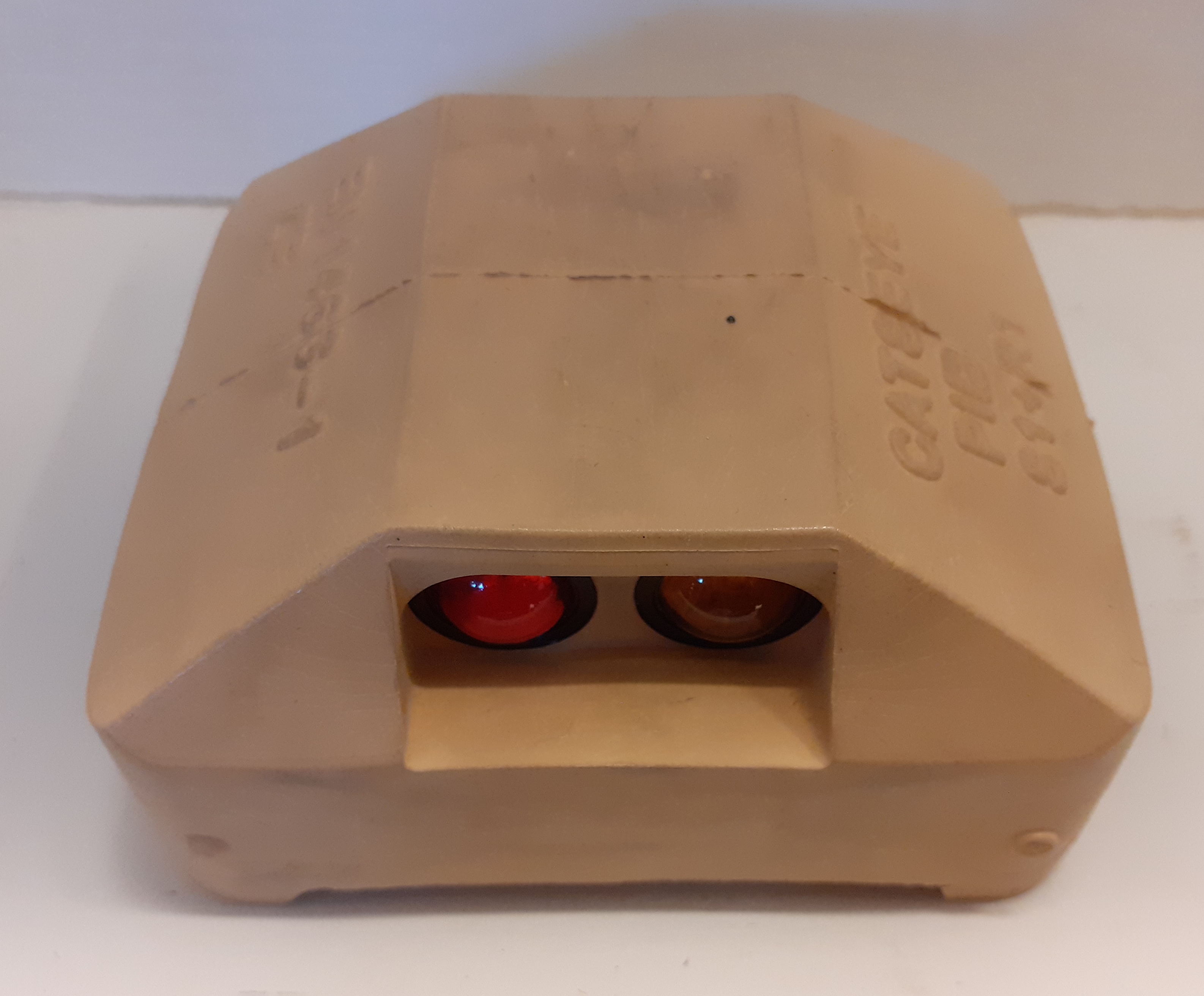 Colour photograph showing a catseye with rubber casing and two reflective bulbs