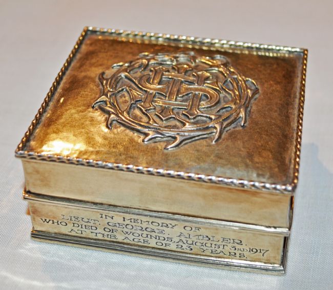 Square silver gilt box with raised design of a crown of thorns on the lid.