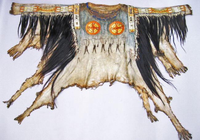 Shirt made from animal skin. It features painted figures representing the many enemies that this warrior has overpowered, whilst the hoof prints symbolise the horses that he has captured and distributed among his people.