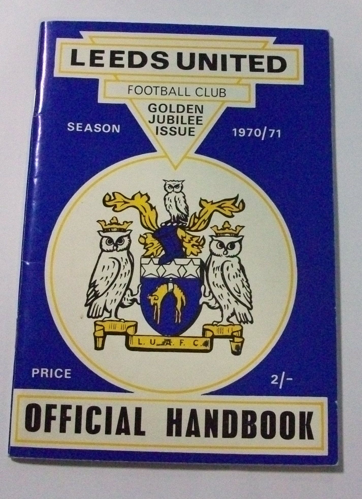 Handbook has a blue cover with the Leeds United crest with owls on the front